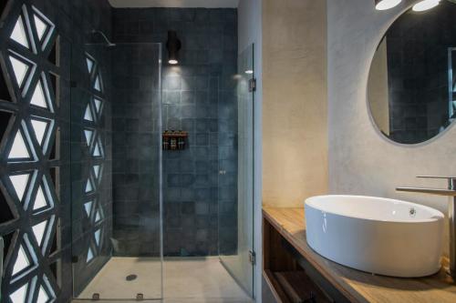 a bathroom with a tub and a glass shower at Hotel Sin Nombre in Oaxaca City