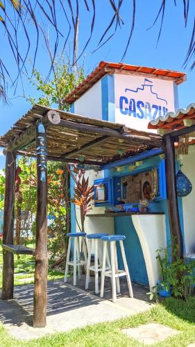a restaurant with two stools under a pergola at Pousada Casa Azul do Piauí in Luis Correia