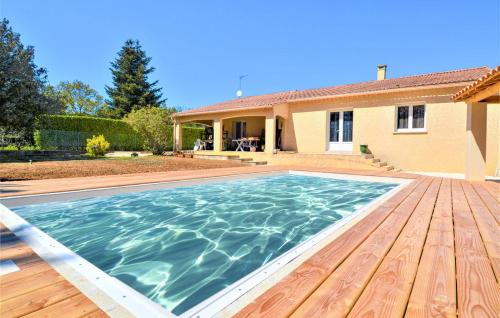 une piscine avec une terrasse en bois devant une maison dans l'établissement gite les oliviers 10 pers piscine au calme 4 Etoiles, à Saint-Laurent-la-Vernède