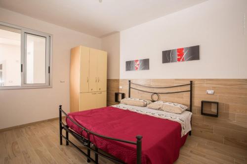 a bedroom with a bed with a red blanket at Casa vacanza Torre Specchia in Torre Specchia Ruggeri