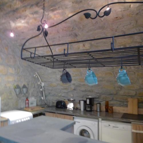 une cuisine avec un support avec des casseroles et des poêles dans l'établissement Gîte du domaine de la Manse, à Villeuneuve-de-Berg