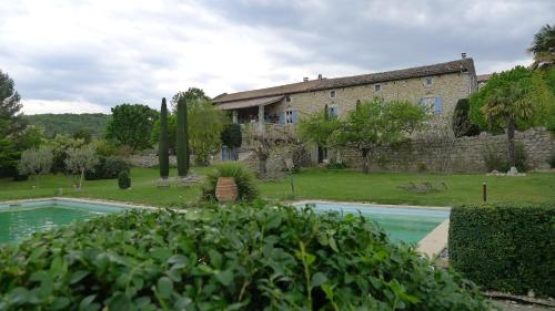 une grande maison avec une piscine devant dans l'établissement Gîte du domaine de la Manse, à Villeuneuve-de-Berg