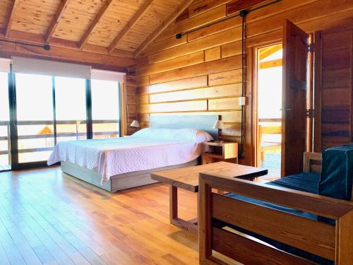 um quarto com uma cama num quarto de madeira em Alma Serrana - Suites de montaña! em La Cumbrecita