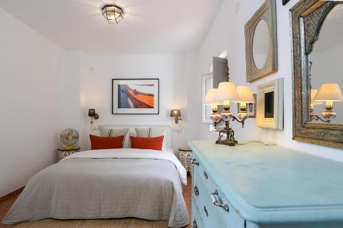 a bedroom with a bed and a blue dresser at Stunning Spanish white village home Private pool Stunning Views in Saleres