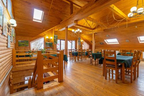 a dining room with wooden floors and tables and chairs at Laguna in Slavske