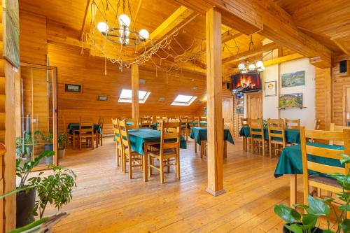 a dining room with wooden floors and tables and chairs at Laguna in Slavske