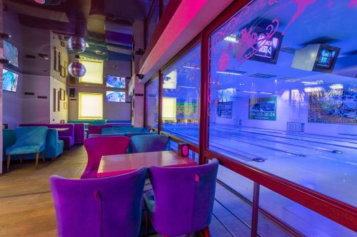 a bowling alley with a table and purple chairs at Laguna in Slavske