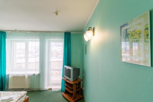 a room with a tv on a table with a window at Laguna in Slavske