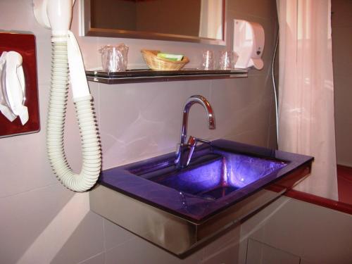 lavabo azul en el baño con teléfono en Auberge Champenoise, en Moussy