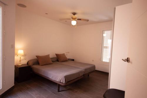 a bedroom with a bed and a ceiling fan at Soling 65 in La Manga del Mar Menor