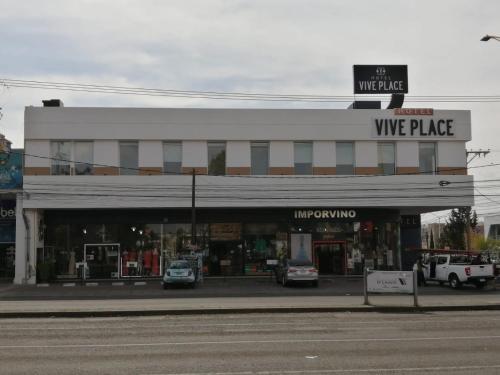 un bâtiment avec des voitures garées devant un magasin dans l'établissement Vive Place, à Aguascalientes