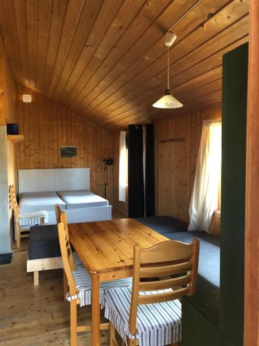 a room with a wooden table and a bed at Nye hytta,Holmfoss/Kvelde in Larvik