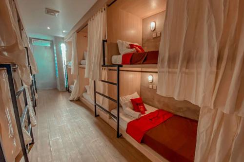a room with three bunk beds in a room at RedDoorz Hostel near Lippo Mall Kuta in Kuta