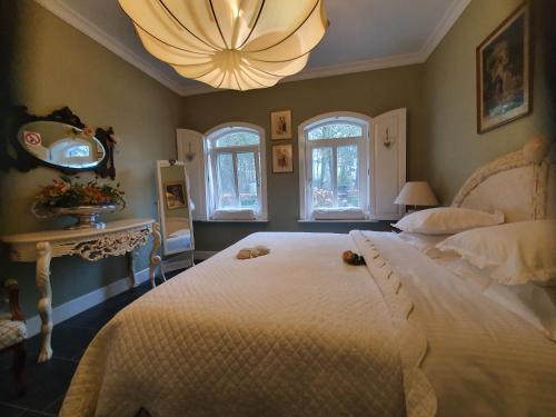 una camera da letto con un grande letto bianco e un lampadario a braccio di de Loverlei a Sterksel