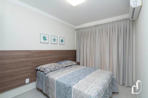 een slaapkamer met een bed in een witte kamer bij Apartamento térreo com 02 dormitórios in Canto Grande