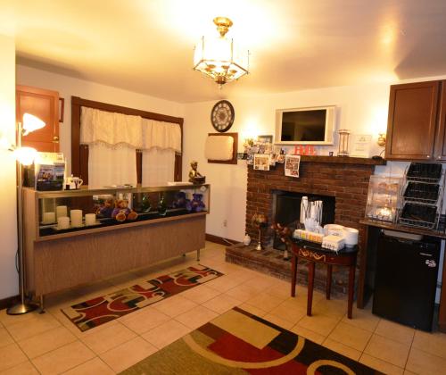 a living room with a kitchen with a fireplace at Williamstown Motel in Williamstown