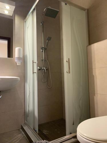 a bathroom with a shower with a toilet and a sink at Balaton Apartmanház in Siófok
