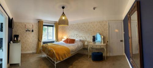 1 dormitorio con cama, escritorio y espejo en Seven Stars Boutique Guesthouse en Exeter