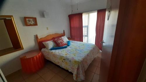 a small bedroom with a bed and a window at Uvongo cabanas 5A in Margate
