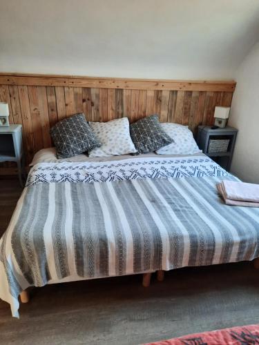 a bedroom with a large bed with a wooden headboard at Ellias in Pont-lʼAbbé