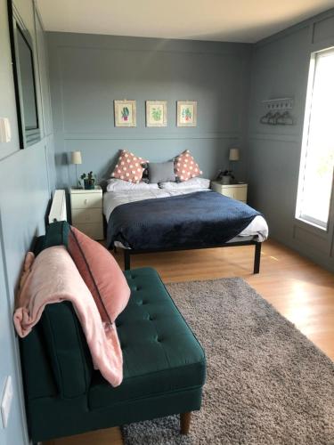 a bedroom with two beds and a green couch at Willow Lodge 2 in North Newton