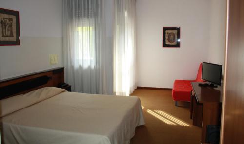 une chambre d'hôtel avec un lit et un fauteuil rouge dans l'établissement Albergo Ristorante Cicin, à Casale Corte Cerro