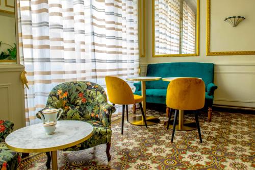 - un salon avec deux chaises et deux tables dans l'établissement Grand hôtel de l'Europe, à Vals-les-Bains