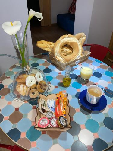 een tafel met een schaal donuts en koffie erop bij Apartamentos Turísticos AbrilyMarzo in Cáceres