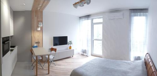 1 dormitorio con cama, escritorio y cocina en Новая Эко-квартира у Метро Славутич, en Kiev