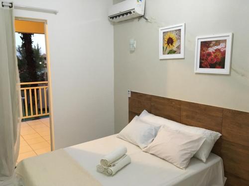 1 dormitorio con cama blanca y cabecero de madera en Blue Beach Apartments, en Aquiraz