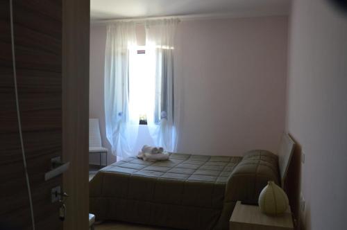 a small bedroom with a bed and a window at Tenuta Terra Tefra in Conca della Campania