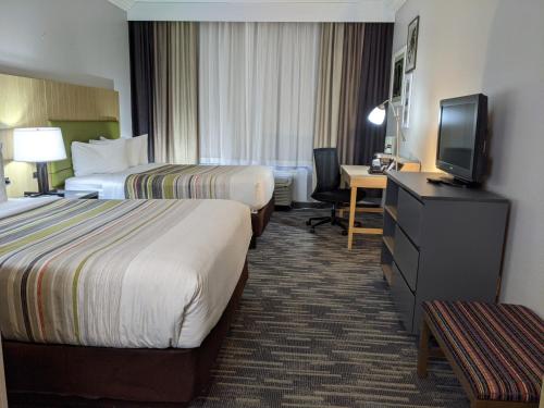 a hotel room with two beds and a flat screen tv at Country Inn & Suites by Radisson, Nashville, TN in Nashville