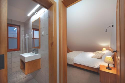 y baño con cama, lavabo y espejo. en Wine & Tourism Bračko 