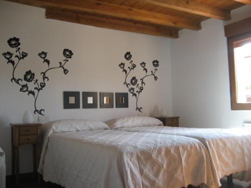 ein Schlafzimmer mit einem Bett mit schwarzen Blumen an der Wand in der Unterkunft Casa Rural Margarita'S in Sotillo de la Ribera