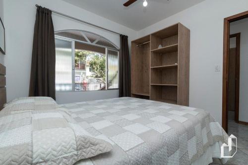 een slaapkamer met een groot bed en een groot raam bij Casa com 03 dormitórios in Bombinhas