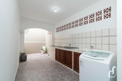 La salle de bains est pourvue d'un lavabo et d'un lave-linge. dans l'établissement Casa com 03 dormitórios, à Bombinhas