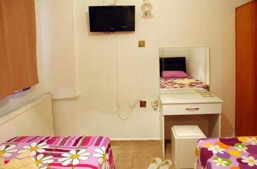 Habitación pequeña con cama y espejo. en Bilsu Volley Hotel, en Cesme