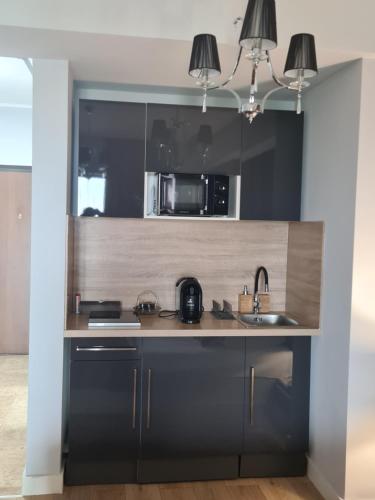 a kitchen with a sink and a microwave at Blue Bike Studio in Mamaia