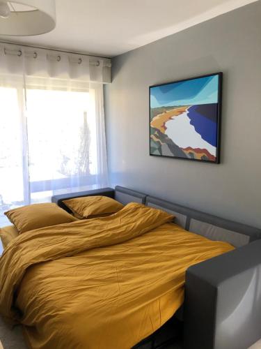 una camera da letto con un letto e un piumone giallo di Appartement rénové en duplex à proximité du centre a Le Palais