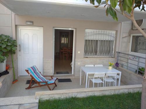 eine Terrasse mit einem Tisch und Stühlen sowie ein Esszimmer in der Unterkunft ΔΕΣΠΟΙΝΑ in Néa Péramos