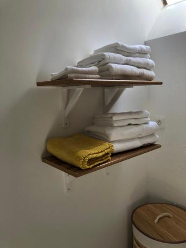 Un mucchio di asciugamani sono sugli scaffali in una stanza di Appartement rénové en duplex à proximité du centre a Le Palais