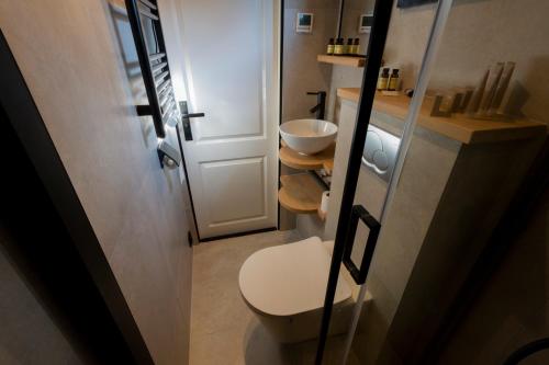 uma pequena casa de banho com WC e lavatório em Hip huisje aan de Maas em Lith