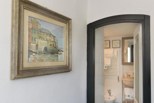 una foto di un bagno con un dipinto sul muro di Salsedine Relais a Genova