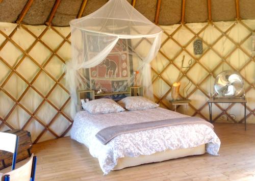 a bedroom with a bed in a yurt at le cri de la yourte in Saint-Urcisse