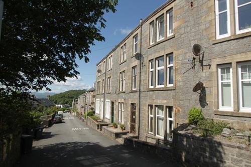 an empty street with a stone building on the side at Apartment D 4 Battery Terrace Oban in Oban