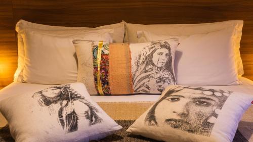 a bed with pillows with a picture of a man at Dellarosa Boutique Hotel and Spa in Marrakech