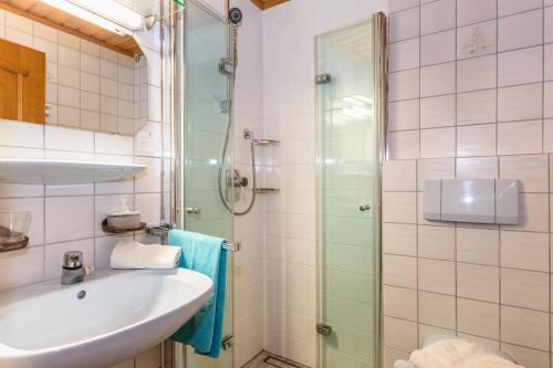 ein Bad mit einem Waschbecken und einer Dusche in der Unterkunft Ferienhaus Hintersee in Hintersee