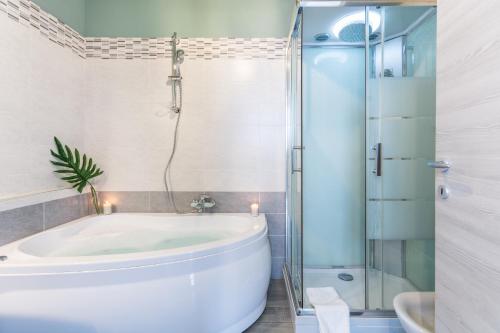 a bathroom with a tub and a glass shower at 4 Star Bologna Train Station - Self Check-In in Bologna