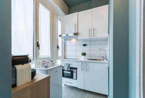 a kitchen with white cabinets and a sink at 4 Star Bologna Train Station - Self Check-In in Bologna