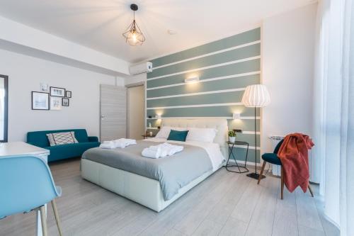a bedroom with a bed and a blue couch at 4 Star Bologna Train Station - Self Check-In in Bologna